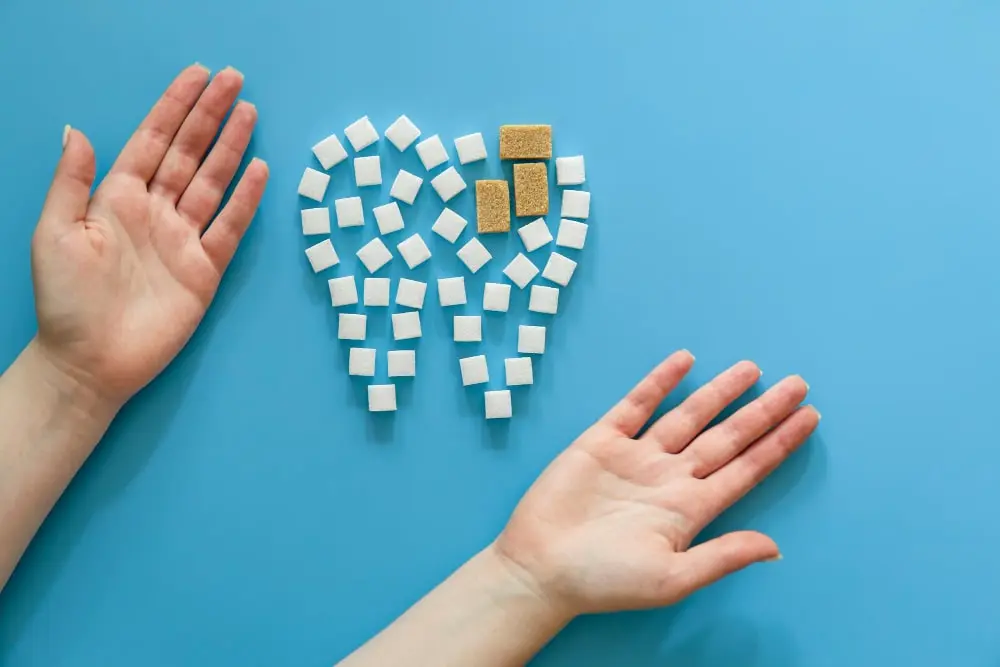 Tooth shape made of sugar cubes with brown spots, symbolizing tooth decay or discoloration treated with dental bonding at Dr. Kaltio Dental in Richmond, BC