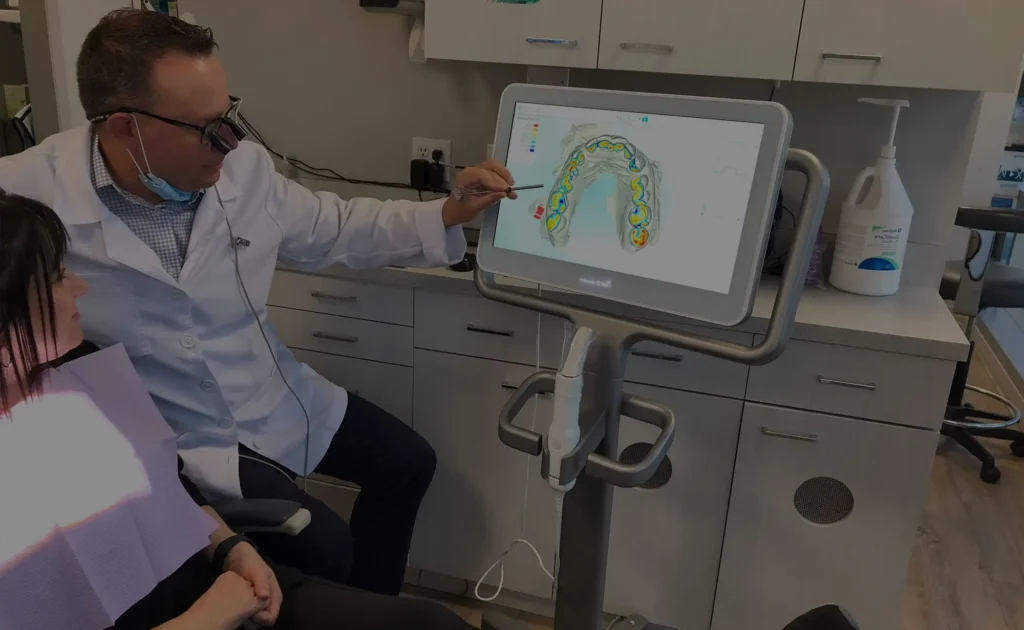 Dr. Ryan Kaltio explaining a digital 3D dental scan to a patient on a screen during a consultation at his clinic in Richmond, BC