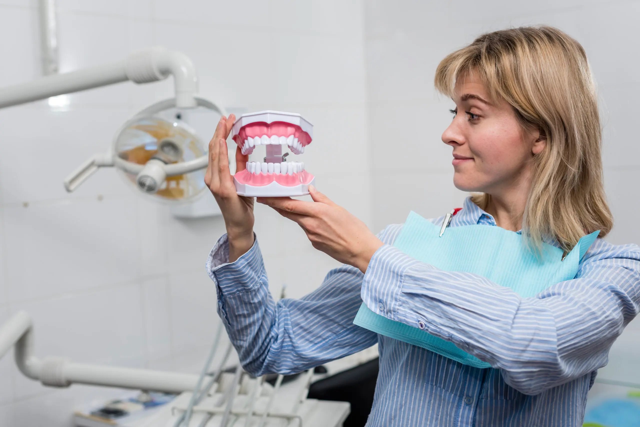 Patient looking at a dental jaw model to understand the stages of gum disease during a consultation at Dr. Kaltio Dental in Richmond, BC